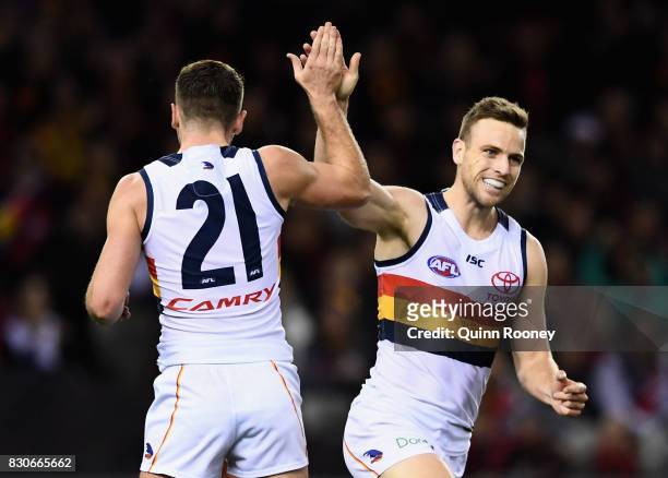 Brodie Smith of the Crows is congratulated by Rory Atkins after kicking a goal during the round 21 AFL match between the Essendon Bombers and the...