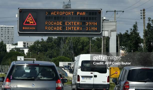 Vehicles drive under a board informing on traffic jam near Bordeaux, southwestern France, on August 12 during the country's summer holidays. Major...