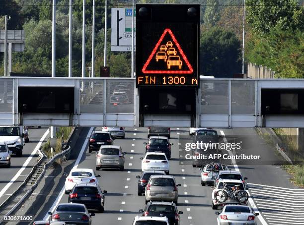 Vehicles drive on a ring road under a board informing on traffic jam near Bordeaux, southwestern France, on August 12 during the country's summer...