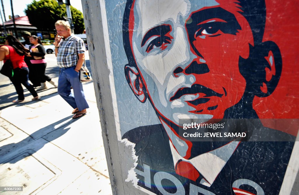 People walk past a campaign poster of US