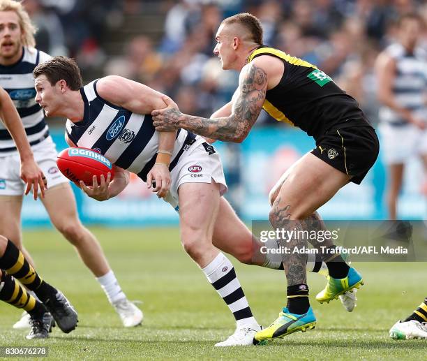 Patrick Dangerfield of the Cats is tackled by Dustin Martin of the Tigers during the 2017 AFL round 21 match between the Geelong Cats and the...