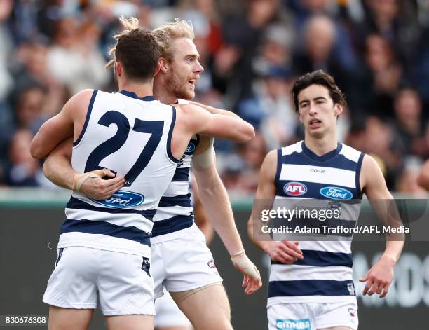 Cameron Guthrie of the Cats celebrates a goal with teammates Sam Menegola and Sam Simpson during the 2017 AFL round 21 match between the Geelong Cats...