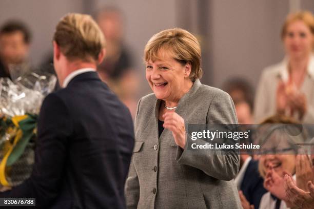German Chancellor and head of the German Christian Democrats Angela Merkel smiles at the CDU federal election campaign opening rally on August 12,...