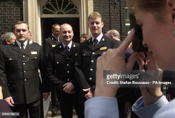 Unidentified policemen have their picture taken outside the door of No.10 Downing St in London as they arrive for a reception for the Police Bravery...