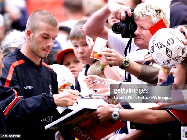 Manchester United's David Beckham signs autographs after fans were admitted to an open training session at Old Trafford, Manchester ahead of Charity...