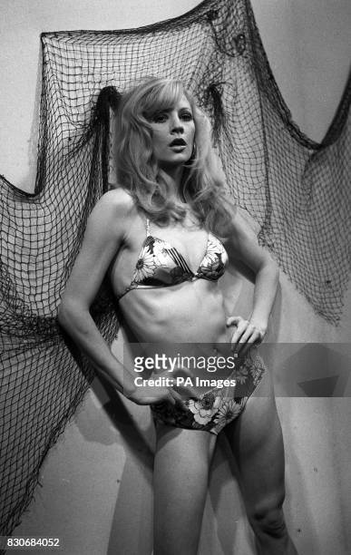Swimwear from Woolworth's is worn by top model Vicki Hodge. She is modelling a floral nylon bikini, with a halter neck, made in navy and purple or...