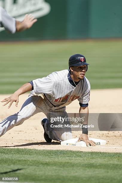 Carlos Gomez of the Minnesota Twins slides safely into third base during the game against the Oakland Athletics at McAfee Coliseum in Oakland,...
