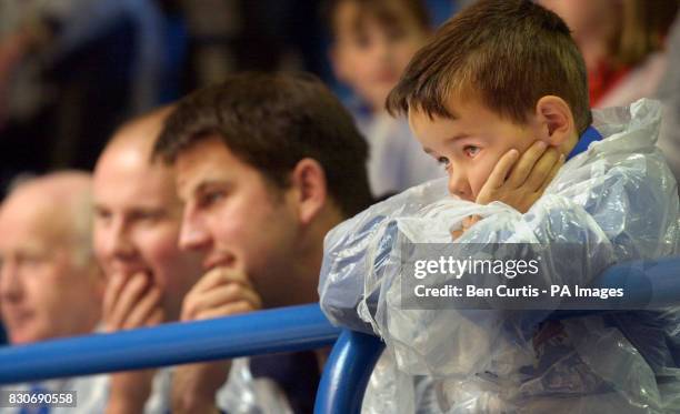 Young boy dressed in a boiler suit and outer plastic protective suit watches closely at the first cattle auction in the UK since the outbreak of...