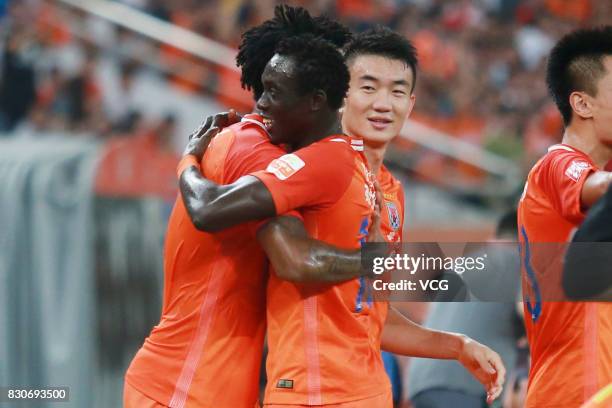 Papiss Demba Cisse of Shandong Luneng celebrates a point with teammate during the 22nd round match of 2017 Chinese Football Association Super League...