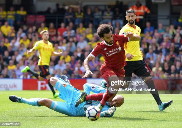 Watford's Brazilian goalkeeper Heurelho Gomes fouls Liverpool's Egyptian midfielder Mohamed Salah to concede a penalty during the English Premier...