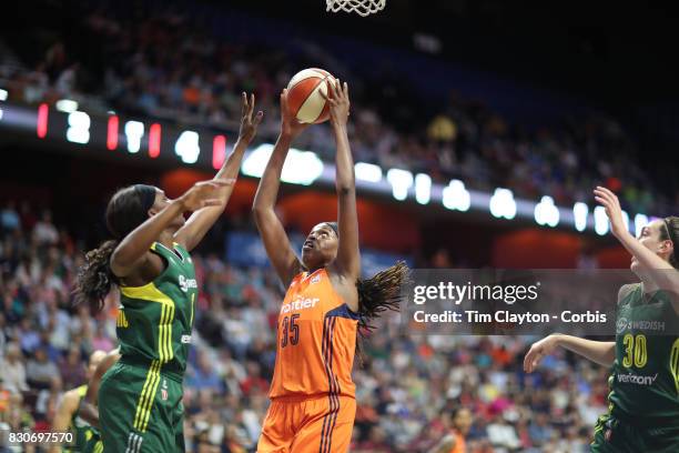 August 8: Forward Jonquel Jones of the Connecticut Sun challenges for a rebound with forward Crystal Langhorne of the Seattle Storm and Breanna...