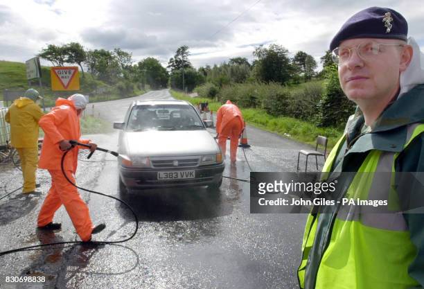 British Army soldiers from the Northumbrian Royal Artillery Regiment spray a vehicle at a disinfecting point in the Allendale area, after they were...