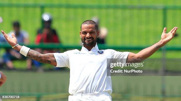 Indian cricketer Shikhar Dhawan celebrates after scoring 100 runs during the 1st Day's play in the 3rd Test match between Sri Lanka and India at the...