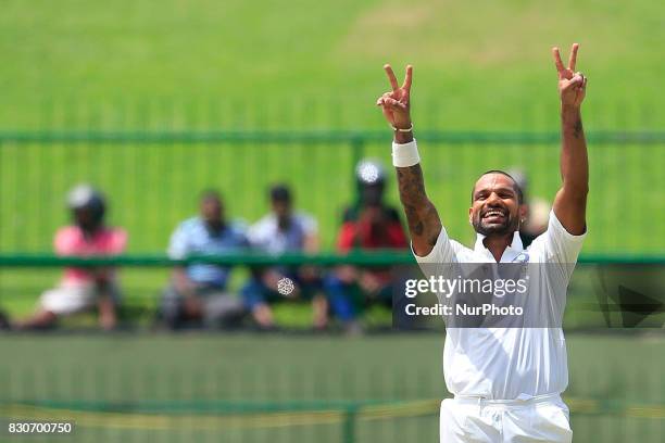 Indian cricketer Shikhar Dhawan celebrates after scoring 100 runs during the 1st Day's play in the 3rd Test match between Sri Lanka and India at the...