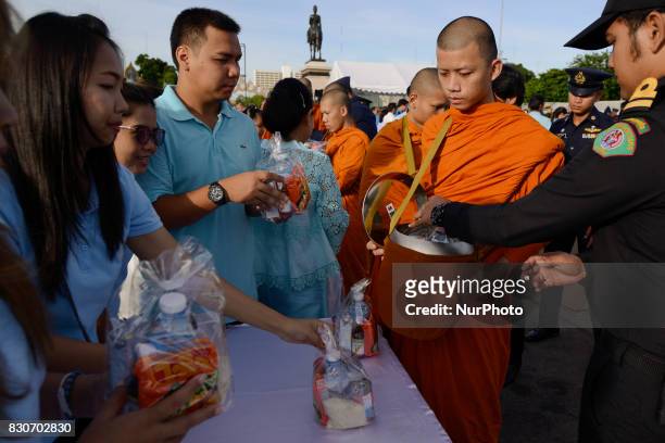 Thai Buddhist devotees give alms to a Buddhist monk as part of celebrate the Queens Sirikit' 85th birthday in Bangkok, Thailand, 12 August 2017.