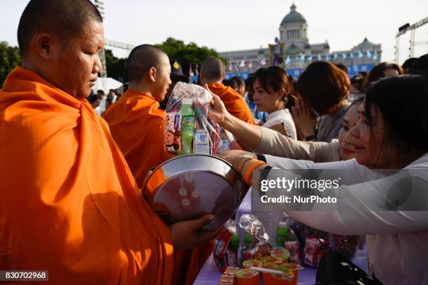 Thai Buddhist devotees give alms to a Buddhist monk as part of celebrate the Queens Sirikit' 85th birthday in Bangkok, Thailand, 12 August 2017.