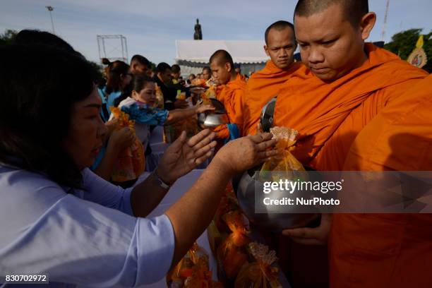 Thai Buddhist monks receive alms during as part of celebrate the Queens Sirikit' 85th birthday in Bangkok, Thailand, 12 August 2017.