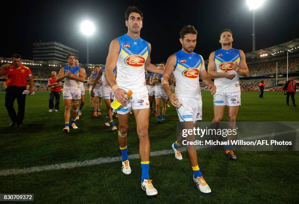 Matt Rosa and Jarrod Harbrow of the Suns lead the team from the field after the 2017 AFL round 21 match between the Brisbane Lions and the Gold Coast...