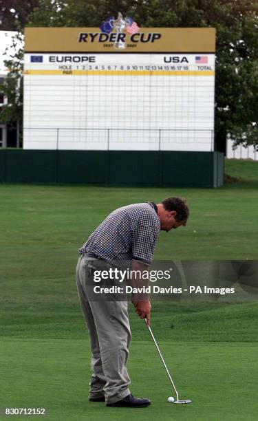 Belfry member Steve Wilkes puts out on the first green of the PGA course with the Ryder Cup scoreboard on the next fairway at the Belfry. The Ryder...