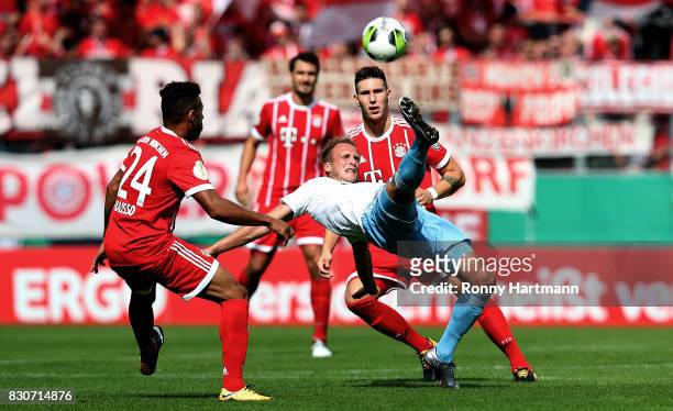 Julius Reinhardt of Cottbus vies with Corentin Tolisso and Niklas Suele of Muenchen during the DFB Cup first round match between Chemnitzer FC and FC...