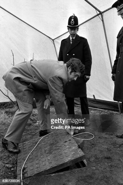 Police raise a manhole cover at Bathpool Park, at Kidsgrove, Staffordshire, to examine the entrance to the shaft at the foot of which was found the...