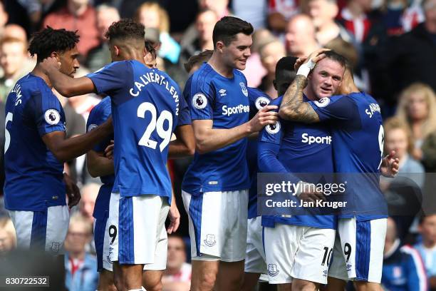 Wayne Rooney of Everton celebrates with teammates after scoring the opening goal during the Premier League match between Everton and Stoke City at...