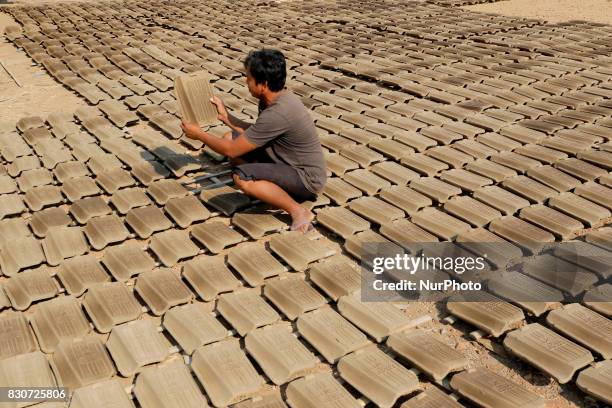 Craftsmen produce tile in Brujul Wetan Village, Majalengka, West Java, on August 2017. When the dry season in a month this traditional factory can...