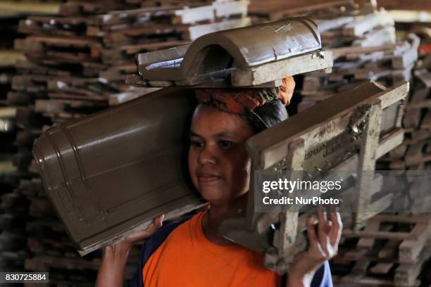 Craftsmen produce tile in Brujul Wetan Village, Majalengka, West Java, on August 2017. When the dry season in a month this traditional factory can...