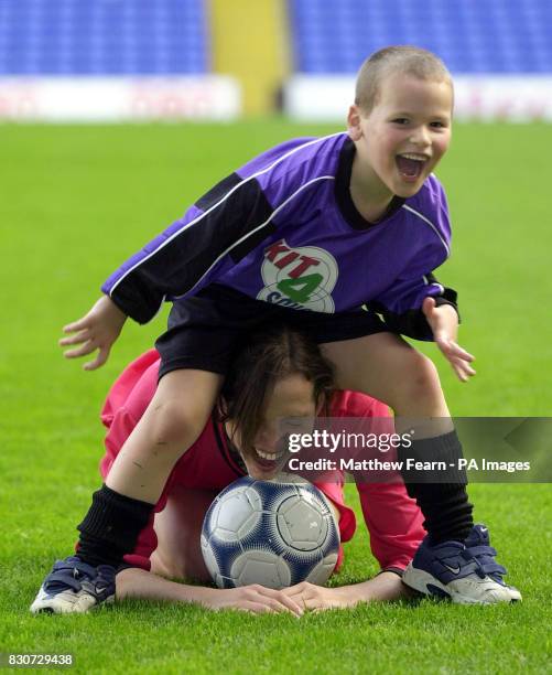 Five-year-old Jake Lunn from Ashford, Kent, leaps over model Kate Groombridge during the launch of Kit 4 Schools at Tottenham's White Hart Lane...