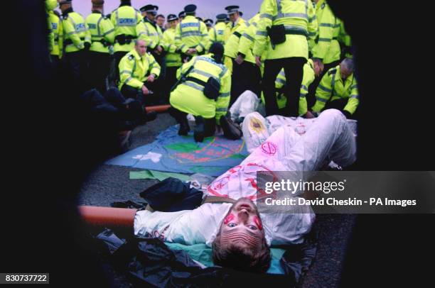 Protester waits to be moved by the police after chaining his arm to a group of protesters at Faslane Naval Base in Scotland, where Britain's 4...