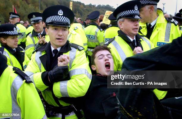 Protester is carried away by police at the anti-war and anti-nuclear demonstration at Faslane Naval Base in Scotland, where Britain's 4 nuclear...