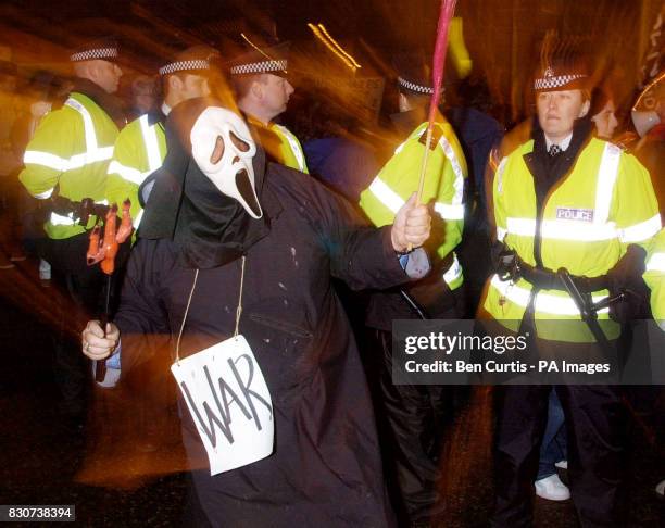 Protester dressed as 'Death' walks down a police line at the anti-war and anti-nuclear demonstration at Faslane Naval Base in Scotland, where...