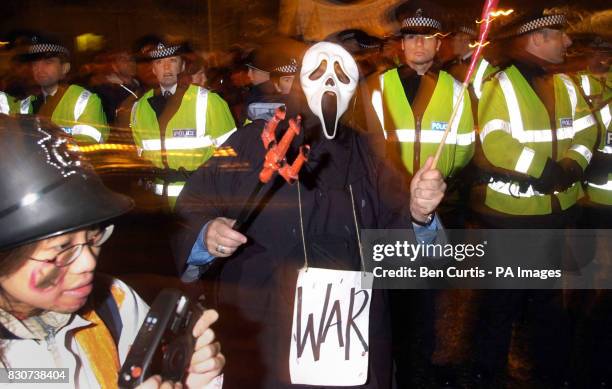 Protester dressed as 'Death' walks down a police line at the anti-war and anti-nuclear demonstration at Faslane Naval Base in Scotland, where...