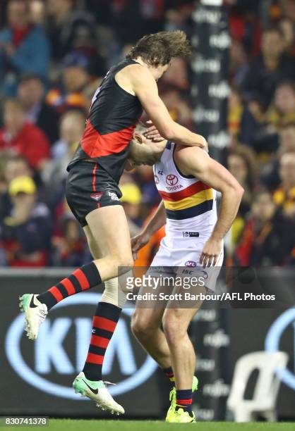 Joe Daniher of the Bombers jumps on Rory Atkins of the Crows as he celebrates after kicking a goal during the round 21 AFL match between the Essendon...