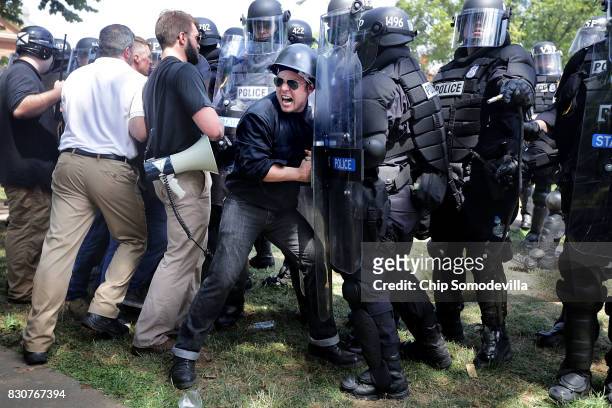 White nationalists, neo-Nazis and members of the "alt-right" clash with police as they are forced out of Emancipation Park after the "Unite the...