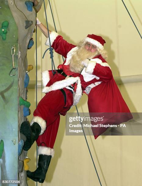 Paul Andrew who is a santa for the Tower Hamlets Housing Association in East London, takes part in the fastest chimney climbing contest during the...