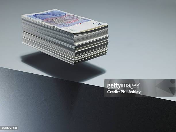 pile of twenty pound notes levitating above edge - british pound sterling note stock pictures, royalty-free photos & images