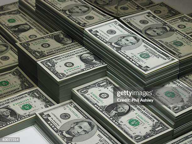 piles of dollar bills reflected in glass - währung stock-fotos und bilder