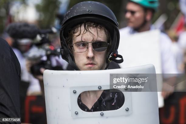 August 12: A White Supremacists with one lens knocked out of his sunglasses holds up a shield during clashes with counter protestors at Emancipation...