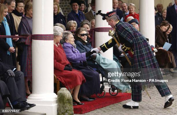Princess Alice sitting with the Queen and Princess Margaret, shakes the hand of Pipe Major, Ewen Stuart, of the King's Own Scottish Borderers at a...