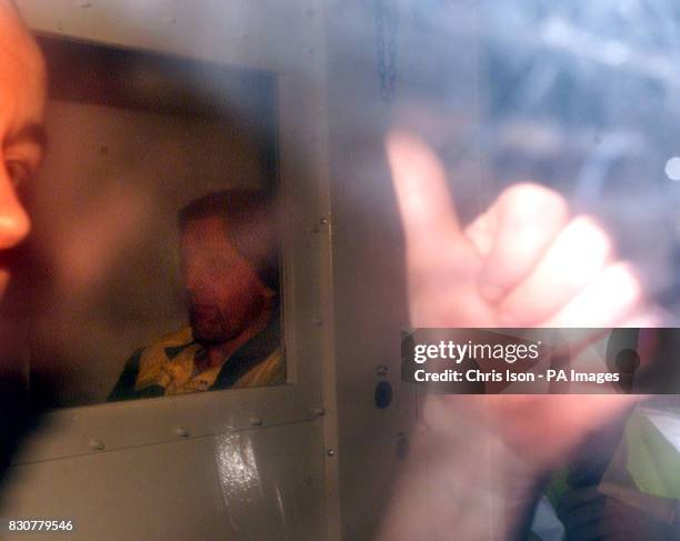 Prison guard escorting Roy Whiting gives the thumbs up to photographers from inside the prison vehicle as it leaves Lewes Crown Court in East Sussex...