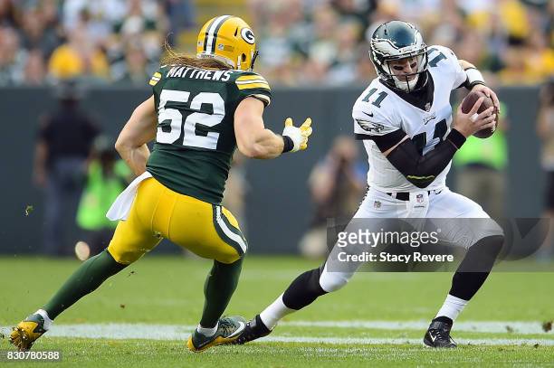 Carson Wentz of the Philadelphia Eagles is pursued by Clay Matthews of the Green Bay Packers during a preseason game at Lambeau Field on August 10,...