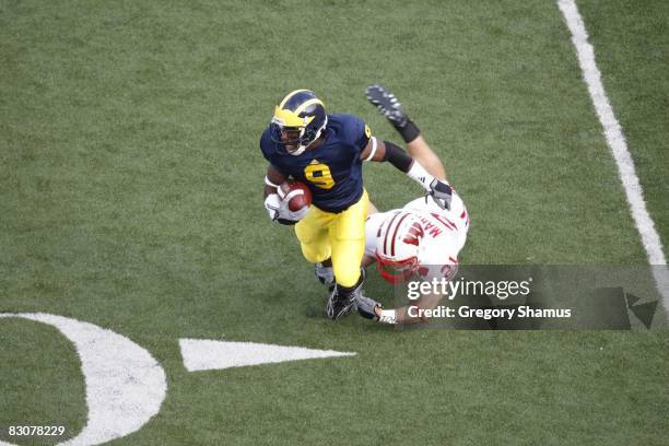 Martavious Odoms of the Michigan Wolverines fights off a tackle from Chris Maragos of the Wisconsin Badgers during the game on September 27, 2008 at...