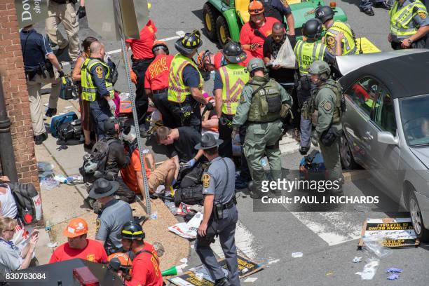 People receive first-aid after a car accident ran into a crowd of protesters in Charlottesville, VA on August 12, 2017. - A picturesque Virginia city...