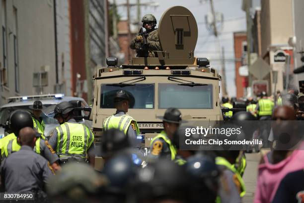 Virginia State Police officer in riot gear keeps watch from the top of an armored vehicle after car plowed through a crowd of counter-demonstrators...