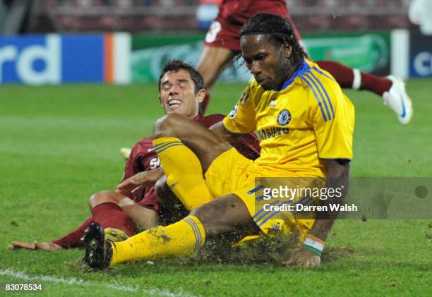 Didier Drogba of Chelsea is injured in a tackle with Andres De Sousa of CFR Cluj-Napoca during the UEFA Champions League Group A match between CFR...