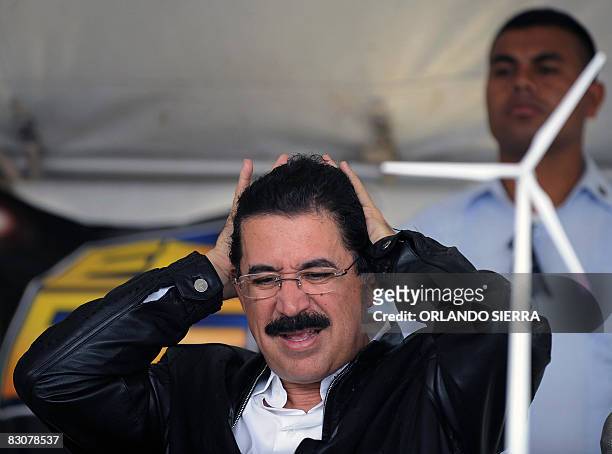 The President of Honduras Manuel Zelaya gestures next to a wind mill model during the signing of an agreement between the National Company of...