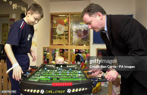 Scottish First Minister Jack McConnell plays table football with Brian Harvey who has appendicitis, as two-year-old Zoe Thomson looks on, in a games...