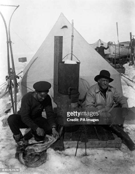 Sir Ernest Shackleton and Frank Hurley in front of their tent on the drifting ice floe called 'Patience Camp'. In the middle can be seen the stove on...
