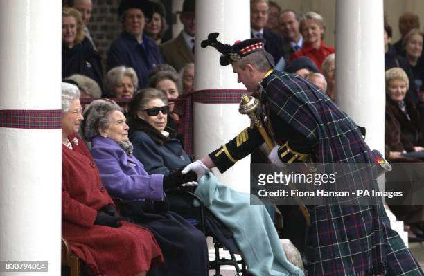 Princess Alice sitting with the Queen and Princess Margaret, shakes the hand of Pipe Major, Ewen Stuart, of the King's Own Scottish Borderers at a...